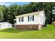 Home's exterior featuring light siding, brick foundation, green lawn, and mature trees at 1617 Mulberry Cir, Rock Hill, SC 29732