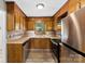 A well-lit kitchen featuring wood cabinets, stainless steel appliances, and tile backsplash at 1617 Mulberry Cir, Rock Hill, SC 29732