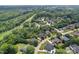 This aerial view shows a residential community with tree-lined streets, homes, and a glimpse of the natural landscape at 184 Melbourne Dr, Fort Mill, SC 29708