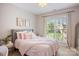 Cozy bedroom with neutral walls, window view, comfortable bed, and decorative floral artwork at 184 Melbourne Dr, Fort Mill, SC 29708