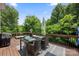 Outdoor deck featuring a dining table, grill, wooden railing, and serene views of lush greenery at 184 Melbourne Dr, Fort Mill, SC 29708