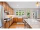 An open kitchen features wooden cabinets, granite countertops, stainless steel appliances, and a view to the backyard at 184 Melbourne Dr, Fort Mill, SC 29708