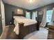 Dark-walled bedroom with hardwood furniture, a double bed, and windows with curtains at 1916 Country Way, Hickory, NC 28601