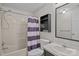 Bathroom with tiled shower/tub combo, single sink vanity, and decorative black shelving at 200 Southwood Park Rd, Mooresville, NC 28117