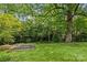 View of the home's backyard with mature trees and a garden at 2005 Scott Ave, Charlotte, NC 28203