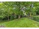 Backyard view of the home with large mature trees and a swing at 2005 Scott Ave, Charlotte, NC 28203
