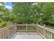 View of the home's wooden deck overlooking a backyard with mature trees and a wooden fence at 2005 Scott Ave, Charlotte, NC 28203