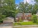 Full view of the brick home with garage, emphasizing curb appeal and surrounding greenery at 2005 Scott Ave, Charlotte, NC 28203