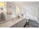 Bright bathroom featuring a double vanity with marble countertop, modern fixtures, and soaking tub at 2011 Fromby Ct, Charlotte, NC 28211