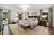 Bright main bedroom with large windows, neutral decor, a padded headboard, and coordinating furniture at 2011 Fromby Ct, Charlotte, NC 28211