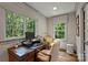 Charming home office featuring built-in desk, vintage chair, and multiple windows for abundant natural light at 2011 Fromby Ct, Charlotte, NC 28211