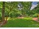 Lush backyard features a wooden playset, mature trees, and a well-maintained lawn at 2011 Fromby Ct, Charlotte, NC 28211