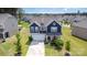 Aerial view of a two-story home with a manicured lawn and a beautiful neighborhood at 205 Falls Cove Dr, Troutman, NC 28166