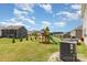 Backyard featuring lush lawn, play set, seating area, and A/C unit at 205 Falls Cove Dr, Troutman, NC 28166