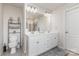 Bright bathroom with double vanity, neutral decor, and visible doorway access to a shower with glass enclosure at 205 Falls Cove Dr, Troutman, NC 28166