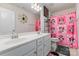 The bathroom features a vibrant pink color scheme with a playful Disney themed shower curtain at 205 Falls Cove Dr, Troutman, NC 28166
