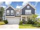 Charming two-story home with a well-manicured lawn and inviting front porch at 205 Falls Cove Dr, Troutman, NC 28166