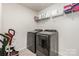 Functional laundry room with updated washer and dryer units, and storage shelves at 205 Falls Cove Dr, Troutman, NC 28166