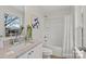 Bathroom with white vanity, granite countertop, mirror, window, toilet, tub, and shower at 207 Putnam St, Shelby, NC 28152