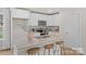 Modern kitchen island with wood stools, granite countertops, stainless steel appliances, and bright lighting at 207 Putnam St, Shelby, NC 28152