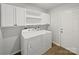 This laundry room offers a washer and dryer with white cabinets and shelves for storage at 232 Branchwood Cir, Kings Mountain, NC 28086