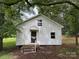 Exterior view of a cozy cottage with white siding, mature trees, and a inviting front entrance at 2350 Grubb Ferry Rd, Salisbury, NC 28144
