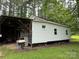 Exterior view of a home with white siding, an outdoor grill, and overgrown vegetation at 2350 Grubb Ferry Rd, Salisbury, NC 28144