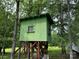 A green-colored elevated outbuilding stands among trees, offering a unique outdoor space at 2350 Grubb Ferry Rd, Salisbury, NC 28144