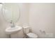 Half bathroom featuring a pedestal sink, elongated toilet, and modern fixtures at 2507 Waverly Dr, Monroe, NC 28112