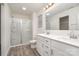 Bathroom featuring double sinks, large mirror, shower with glass door, and wood-look flooring at 2507 Waverly Dr, Monroe, NC 28112