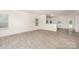 Open-concept living room featuring modern laminate flooring and an adjacent kitchen with white cabinetry at 2507 Waverly Dr, Monroe, NC 28112