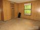 Bedroom with wood paneling, small closet, and single window at 2927 S Nc 16 Hwy, Newton, NC 28658