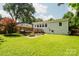 Spacious backyard with a well-manicured lawn, garden beds, and access to the back of the house at 3307 Draper Ave, Charlotte, NC 28205