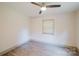 Simple bedroom featuring a ceiling fan, single window and neutral tones, with wood-look flooring at 3307 Draper Ave, Charlotte, NC 28205