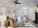 Open-concept living room with wood floors flowing into the dining area, complete with fireplace and ceiling fan at 3307 Draper Ave, Charlotte, NC 28205
