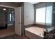 A view into the bedroom shows the soaking tub with grey ceramic tiling at 4003 Northerly Island Ct, Gastonia, NC 28056