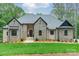 Stunning stone-and-brick home with a well-manicured lawn, covered entry, and gray shingle roof at 4028 Spindrift Cove Dr # 59 And 60, Denver, NC 28037