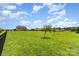 Well-maintained backyard with green grass, complemented by scattered trees and a fence line at 410 Alucio Ct, Matthews, NC 28104