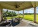 Inviting covered patio with outdoor seating, a ceiling fan, and scenic views of the open backyard at 410 Alucio Ct, Matthews, NC 28104
