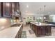 Modern kitchen with dark wood cabinets, stainless steel appliances, spacious island, and open concept design at 410 Alucio Ct, Matthews, NC 28104