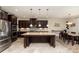 Modern kitchen featuring stainless steel appliances, dark wood cabinets, and a large central island at 410 Alucio Ct, Matthews, NC 28104