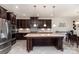 Open-concept kitchen featuring dark wood cabinets, stainless steel appliances and a breakfast nook at 410 Alucio Ct, Matthews, NC 28104