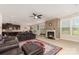 Open-concept living room with stone fireplace and dark leather furniture and nearby kitchen and breakfast nook at 410 Alucio Ct, Matthews, NC 28104