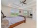 This main bedroom boasts a tray ceiling, fan, and large windows offering an abundance of natural light at 410 Alucio Ct, Matthews, NC 28104