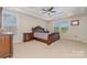 This elegant main bedroom features a decorative bed frame, a ceiling fan and bright natural light at 410 Alucio Ct, Matthews, NC 28104