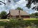 Charming brick home featuring a large backyard with a patio and mature trees providing shade at 4402 Poxon Ln, Monroe, NC 28110
