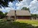 Brick home showcasing a spacious backyard and a chimney, blending natural beauty with architectural charm at 4402 Poxon Ln, Monroe, NC 28110