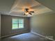 Bedroom featuring a tray ceiling, ceiling fan, and a window at 4402 Poxon Ln, Monroe, NC 28110