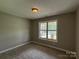 Neutral bedroom featuring carpet, one window allowing natural light, and ceiling light fixture at 4402 Poxon Ln, Monroe, NC 28110