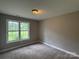 Bright bedroom featuring neutral carpet, window allowing natural light, and ceiling light fixture at 4402 Poxon Ln, Monroe, NC 28110